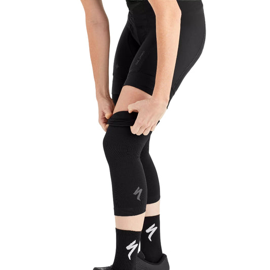 Person wearing black leggings with a brand logo on a white background