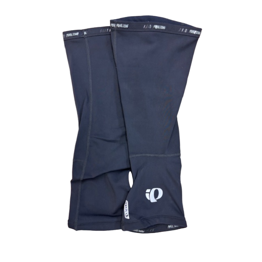Pair of black cycling shorts with a brand logo on a wooden surface