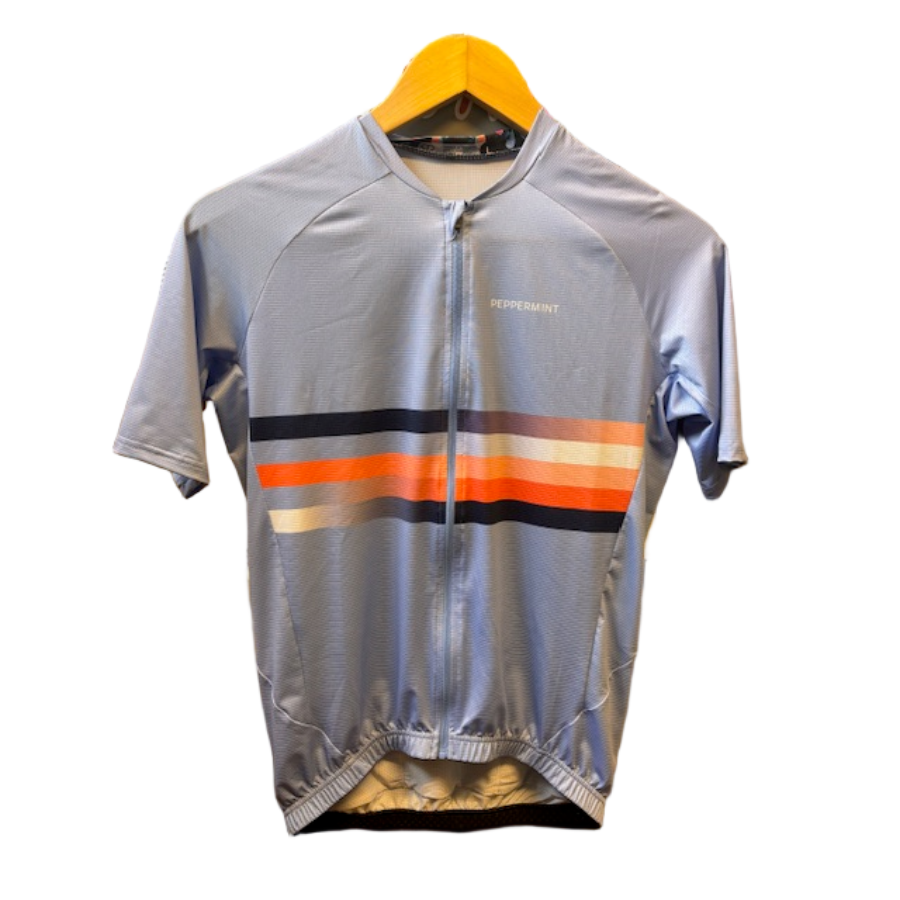 Cycling jersey with colorful stripes on a hanger against a metallic background