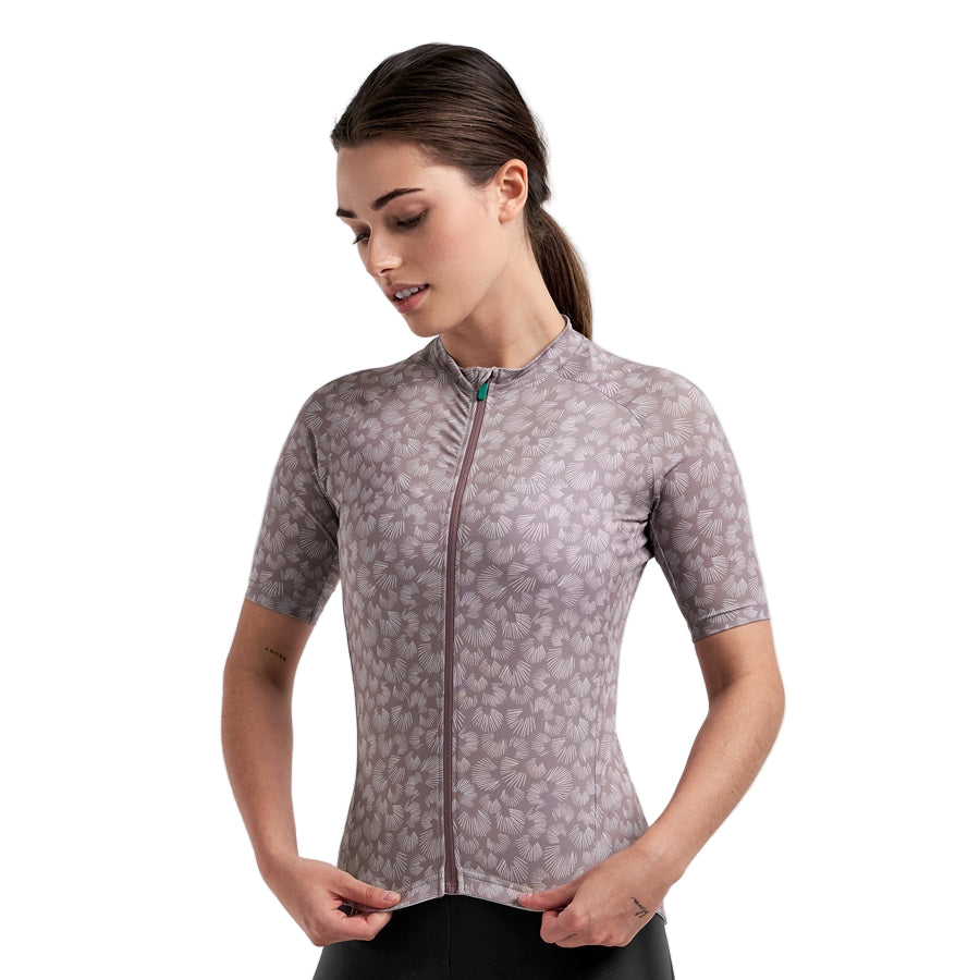 Woman wearing a PEPPERMINT Classic patterned cycling jersey on a light gray background