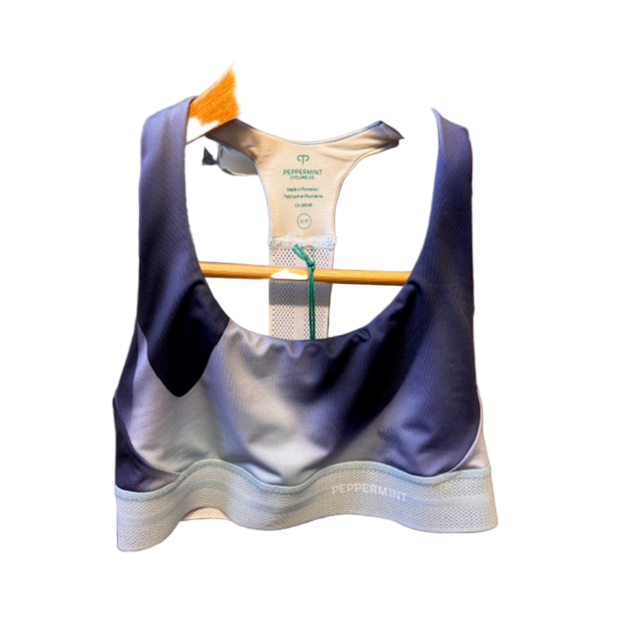 Navy and gray sports bra on a hanger with a visible brand label.