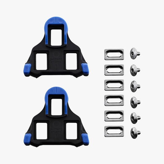 Two black cleat plates with blue accents and multiple metal pins on a white background
